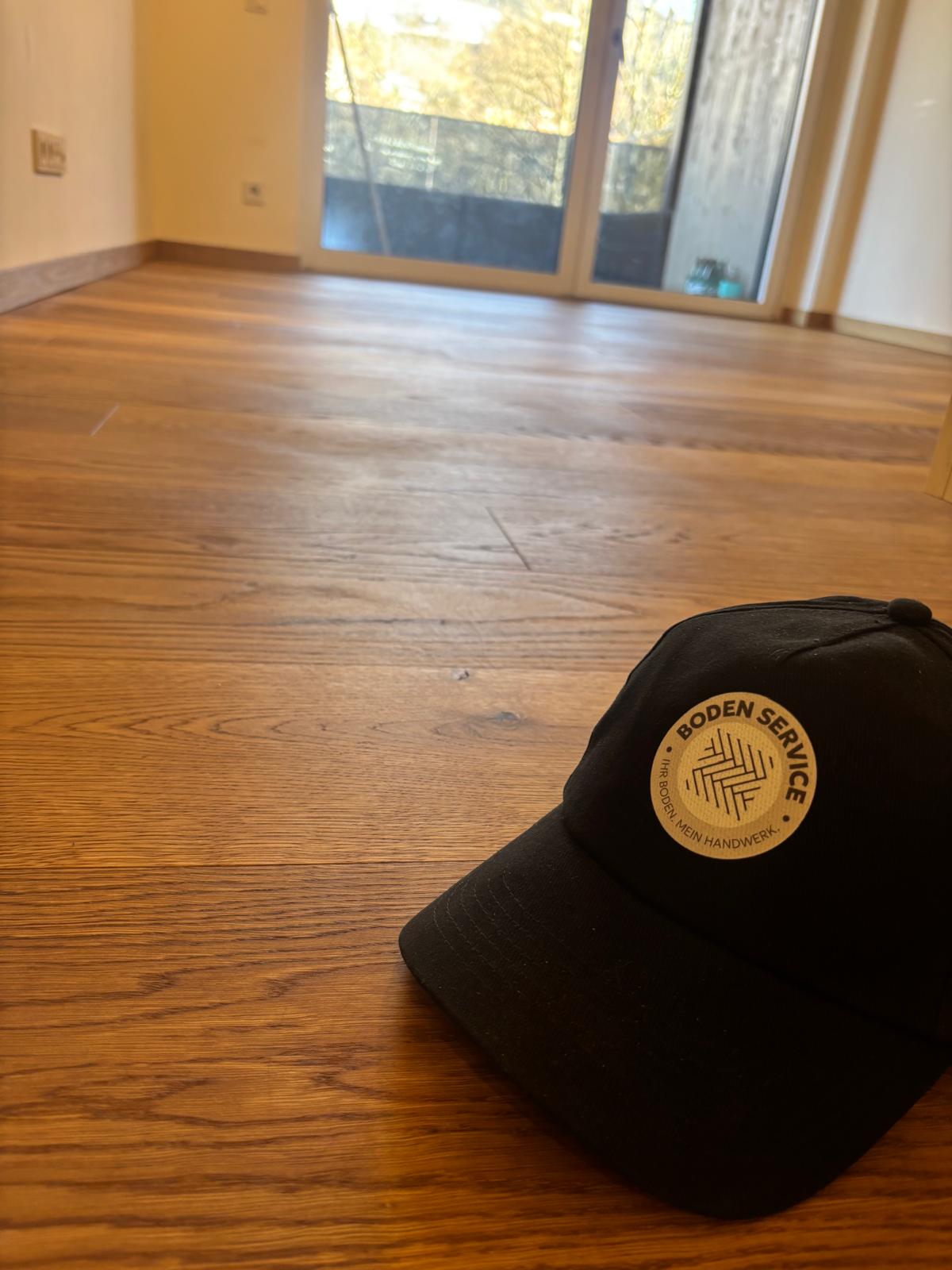 Boden Service Cap auf warmem Eichenparkett
