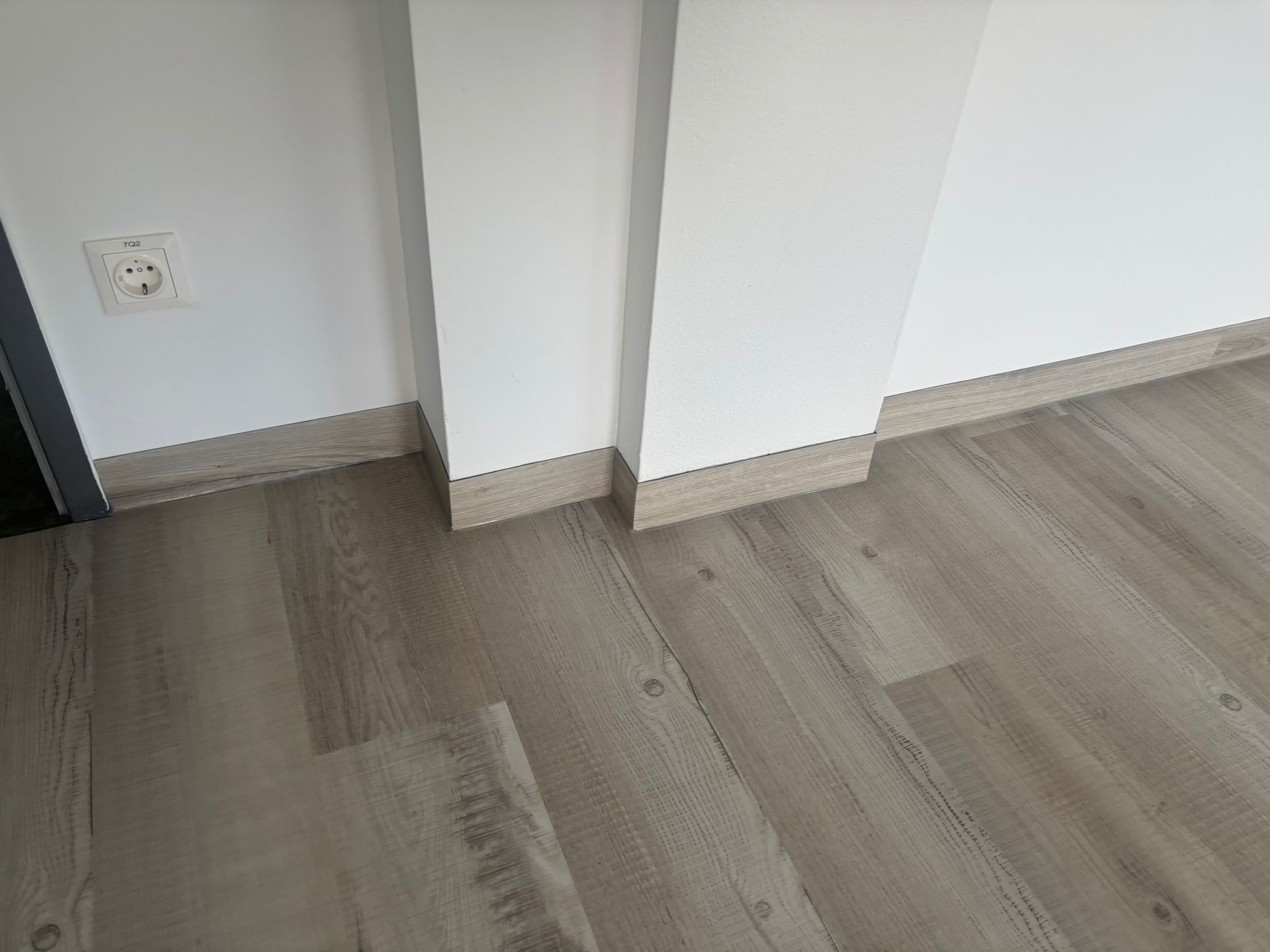 Grauer Vinylboden mit Sockelleiste